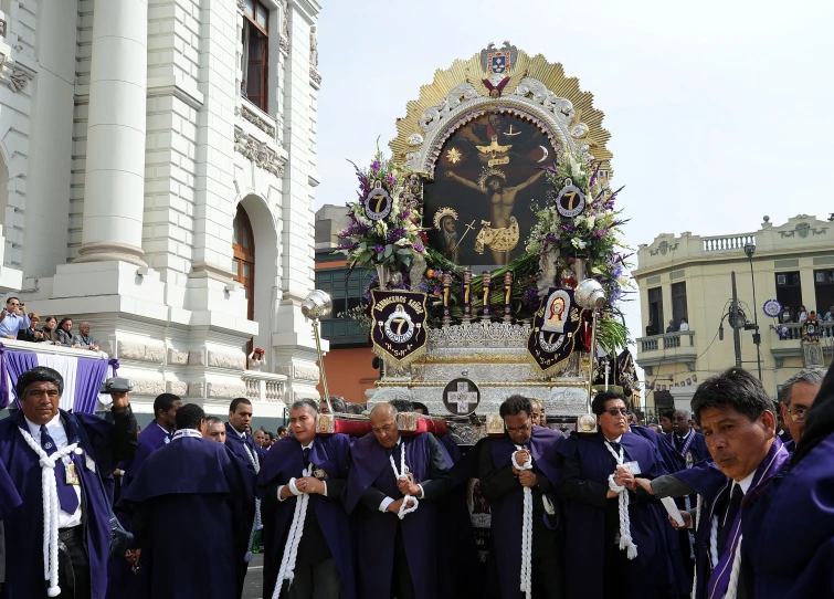 several priests gathered together around a large gold statue