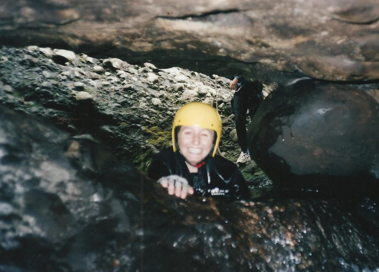 a woman with yellow safety gear on in the middle of a cave