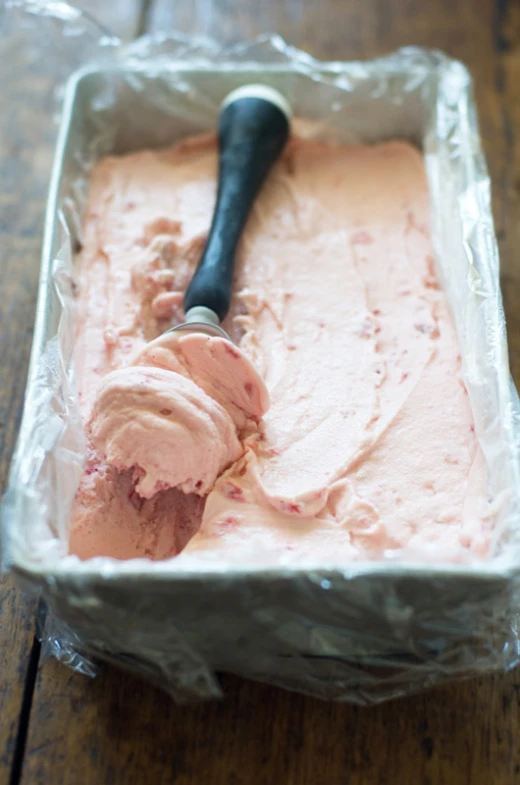 a scoop full of pink colored ice cream on aluminum foil