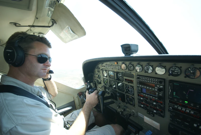 the pilot is sitting at the controls of his airplane