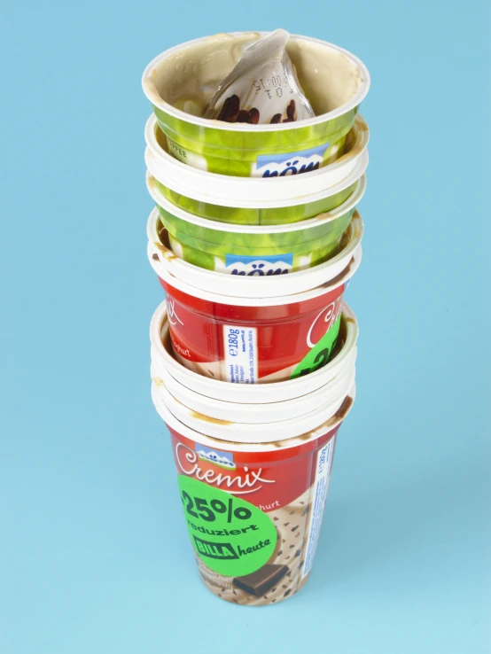 four plastic cups containing yogurts, bananas and dessert