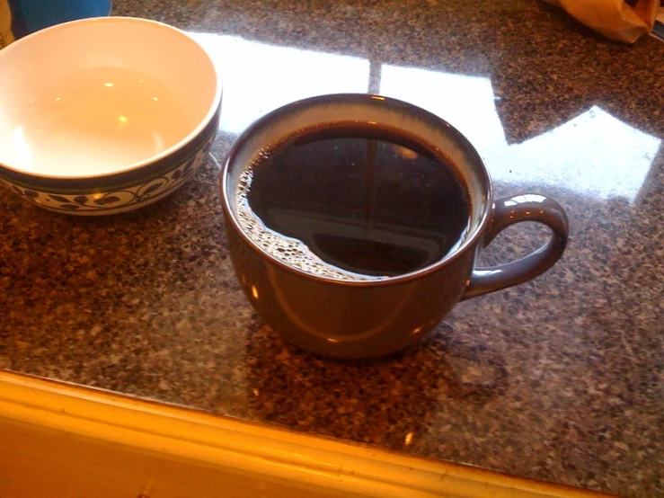 cup and bowl sitting on marble counter top