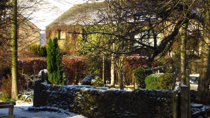 a wall with a stone fence around it and trees in the background