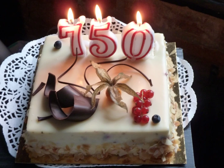 a cake with lit candles has the words 105 on it