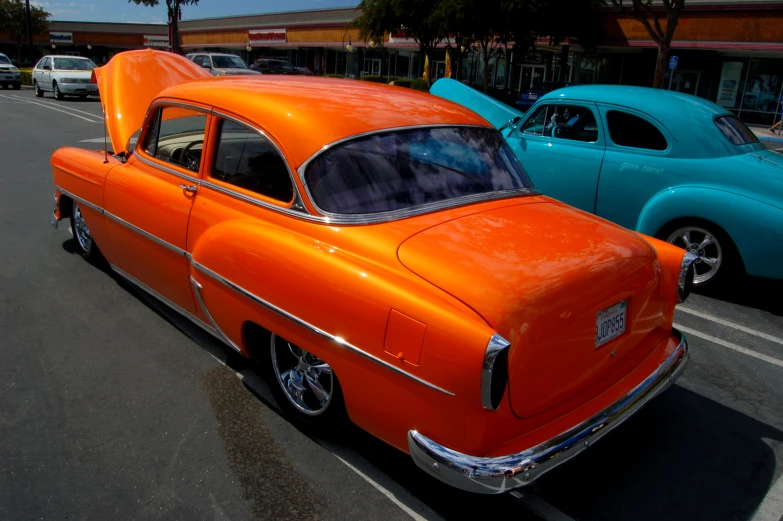 an orange and blue car sitting on the side of a street