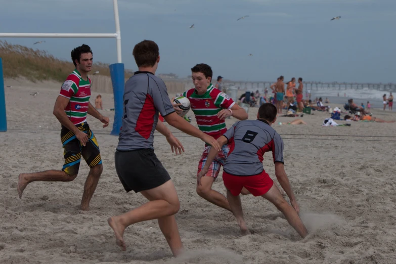 a group of people on a beach playing with a frisbee