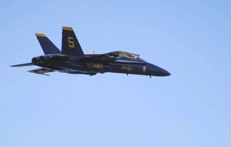 a fighter jet flies through the sky during the day