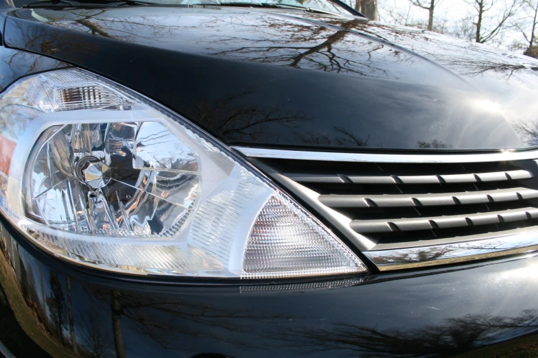 a close up of the headlights of a black sports car