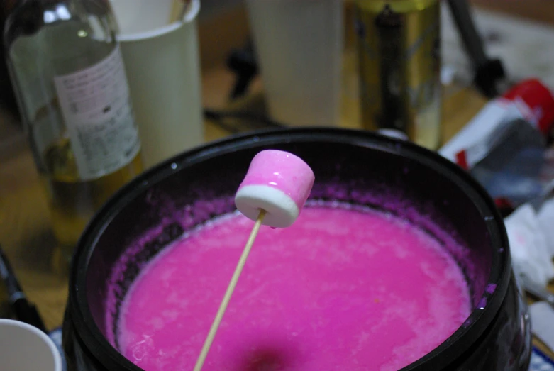 the pink liquid is being heated up in a bowl