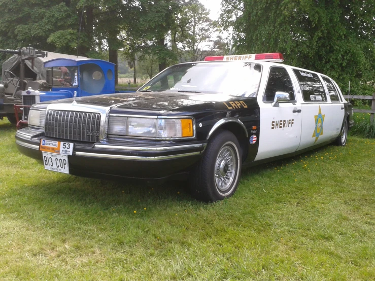a black and white limo that is parked in the grass