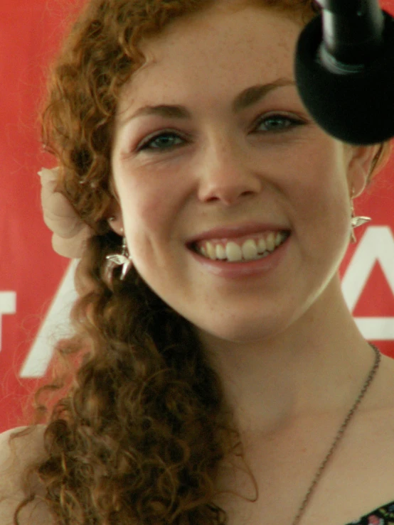 a woman holding up an umbrella smiling for the camera