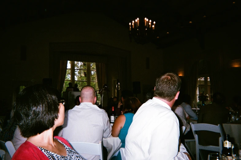 a man standing in front of a group of people at a restaurant