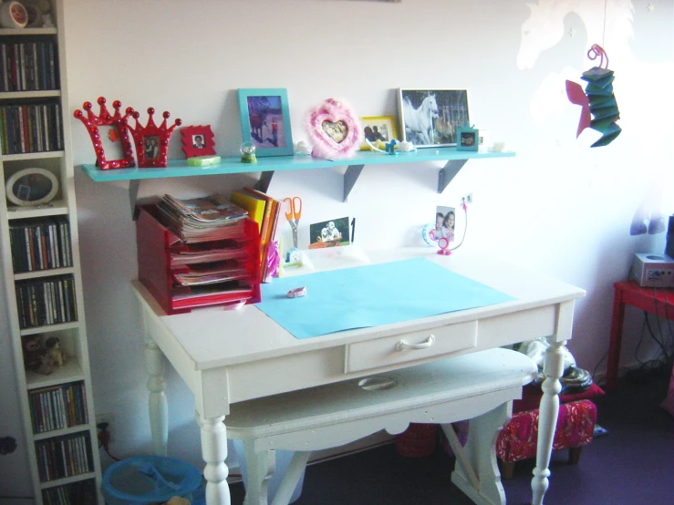 this is a desk with items and shelves in the corner