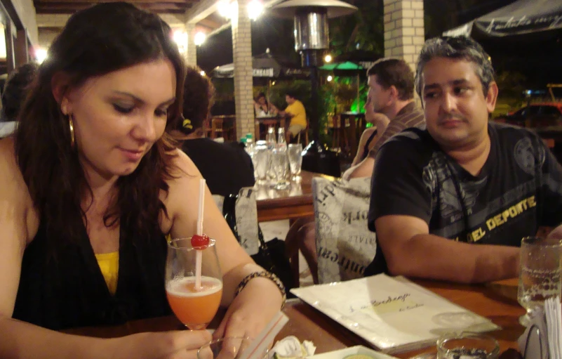 a man and woman seated in a restaurant drinking drinks