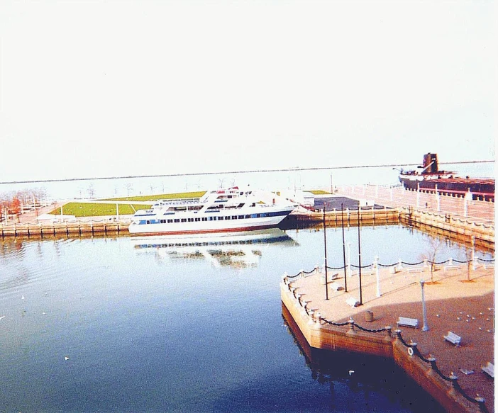 a big boat docked near some water and trees