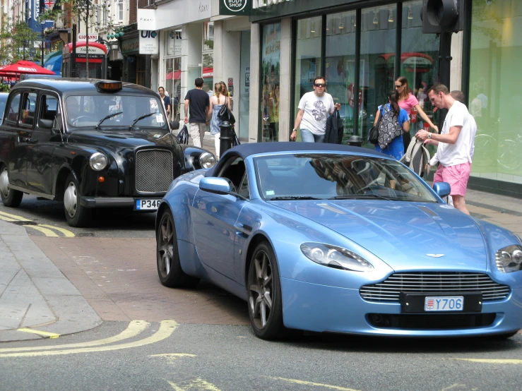 people walking past cars on the street with one of them driving