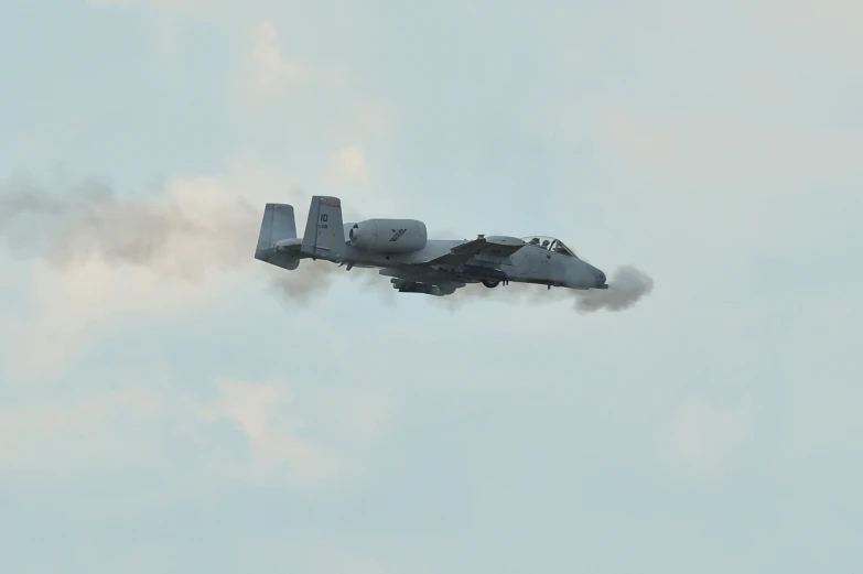 a jet flying in the air with smoke coming from it