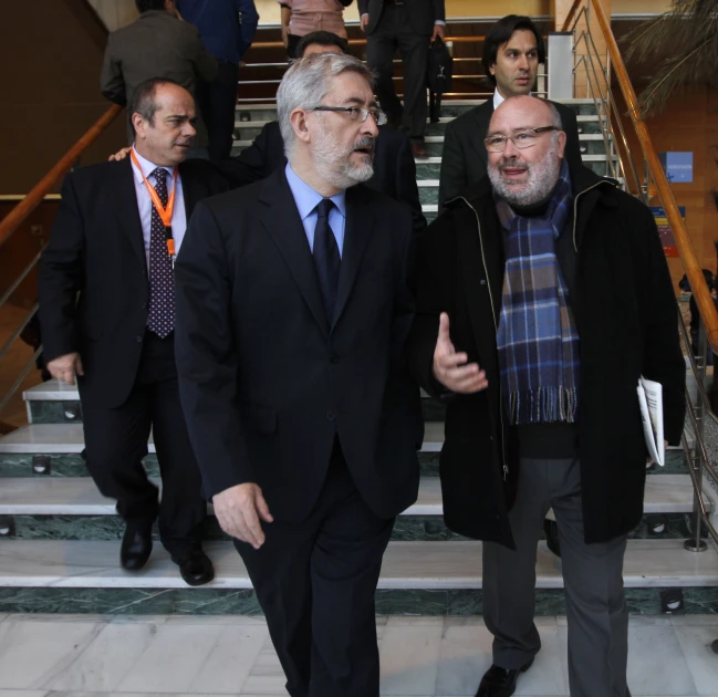 two men in suits walking up stairs, one man in blue tie