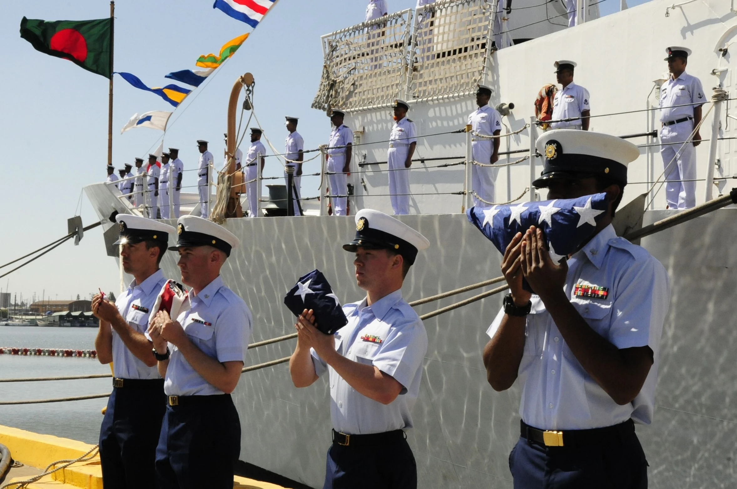 a group of uniformed men standing on top of a ship