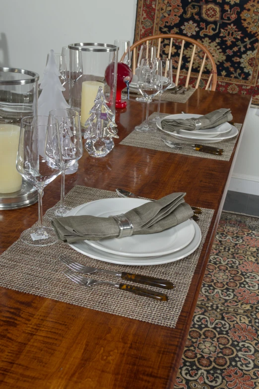 an empty wooden table is set for formal entertaining