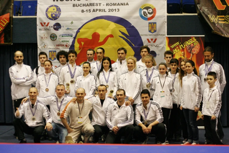 a group of men and women who are standing in front of a banner