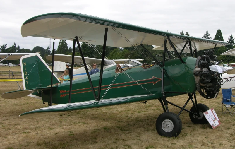 a green plane with people sitting in it