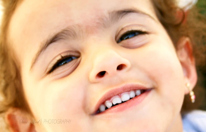 close up of young child smiling with white teeth