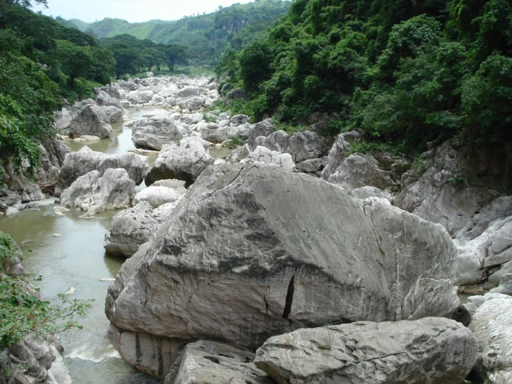 a river running between some large rocks on a hill