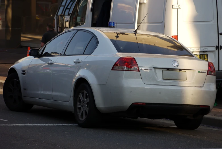 a white vehicle is shown at a curb