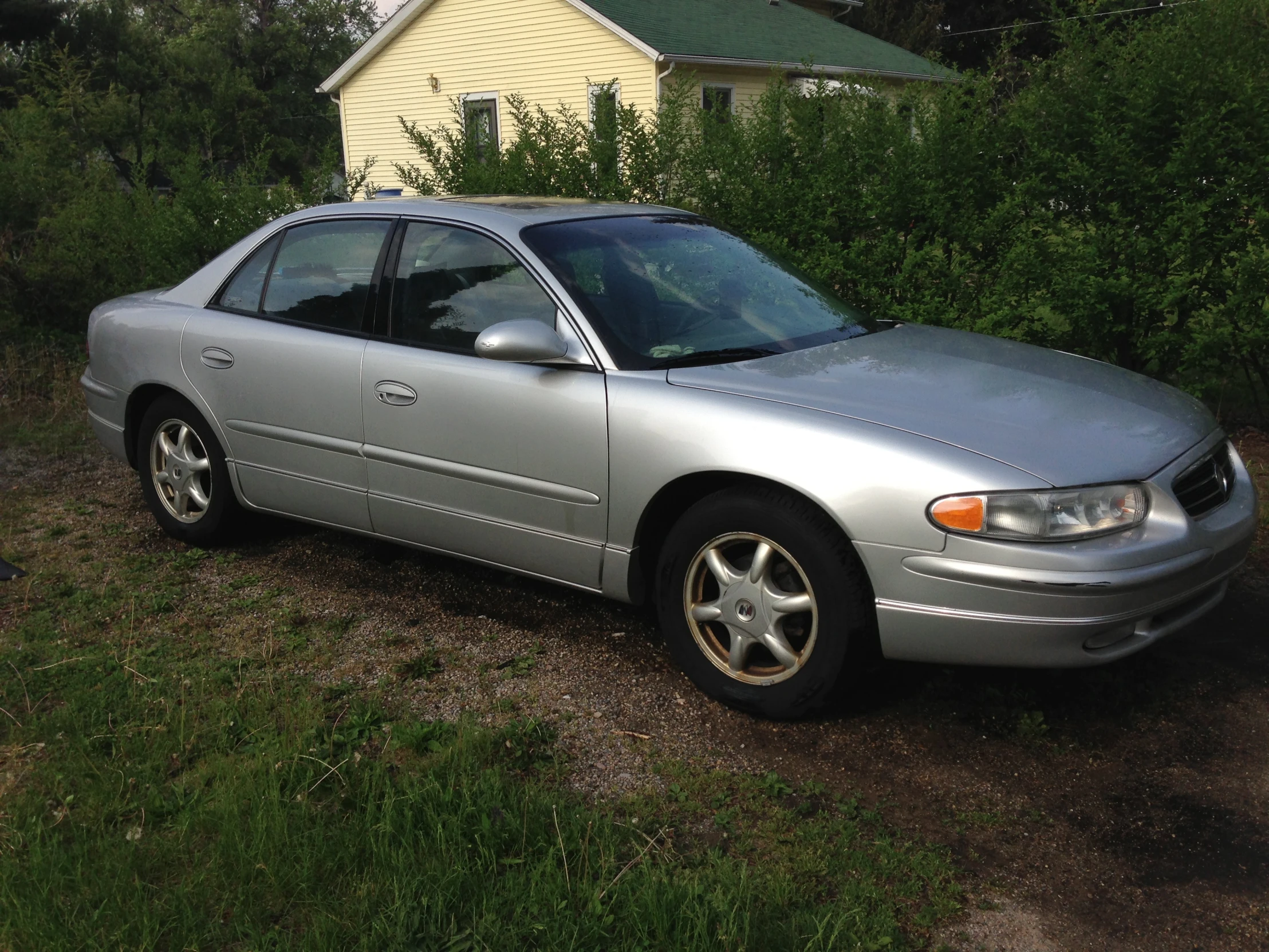 a silver sedan car parked on the side of the road