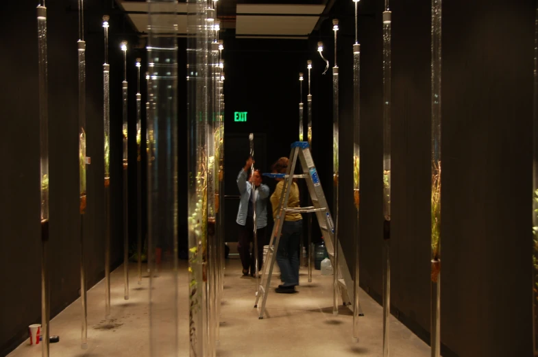 people walking down a hallway near mirrors in a building