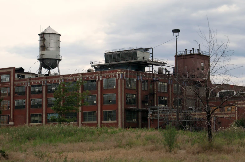 a building with a water tower on top that looks like it has been destroyed in the middle of a city