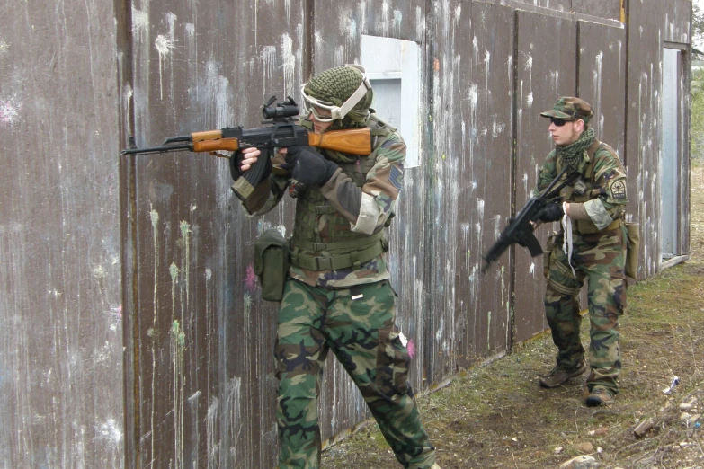 two men in camouflage uniforms holding a gun