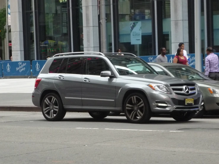 a mercedes benz is parked on a corner of a city street