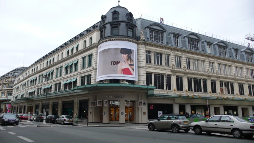 a large white building with a woman advertit on it