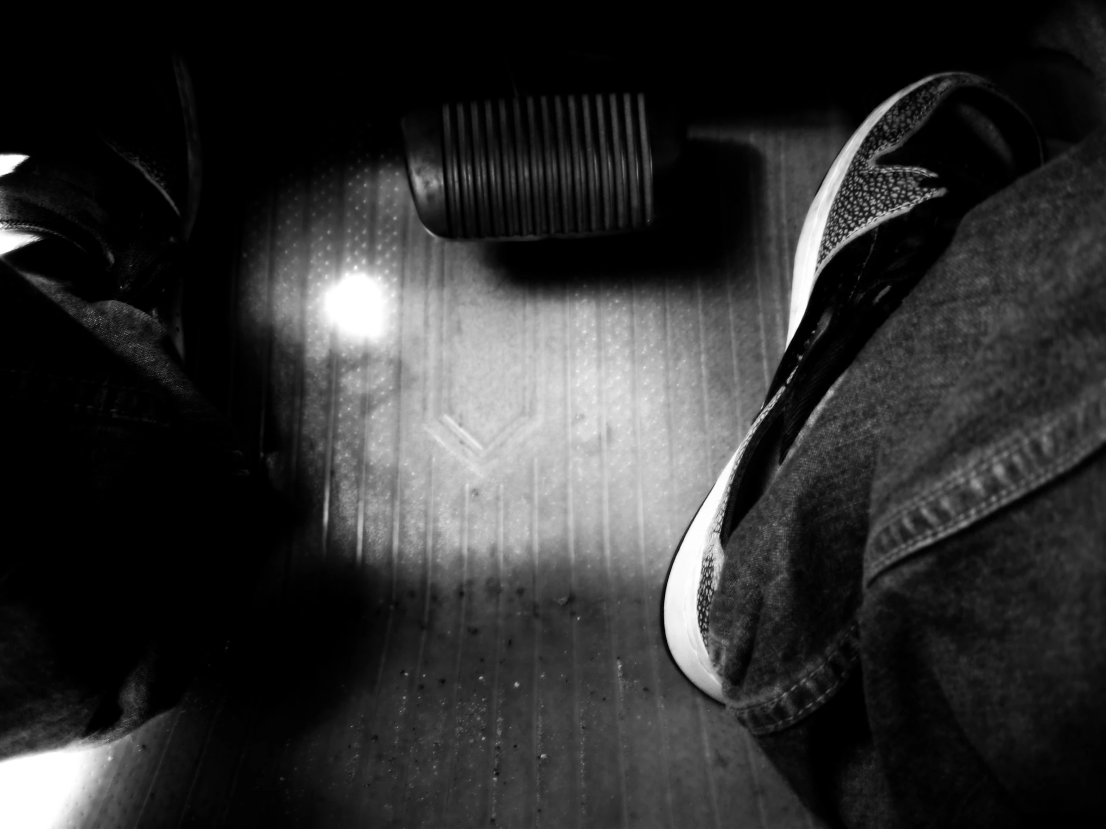 a persons legs in black and white standing on a wooden floor