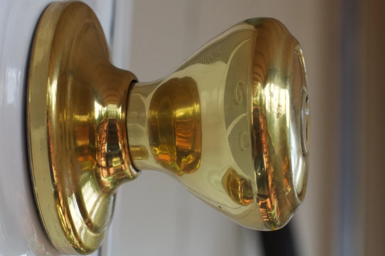 close up of a gold door handle on a white door