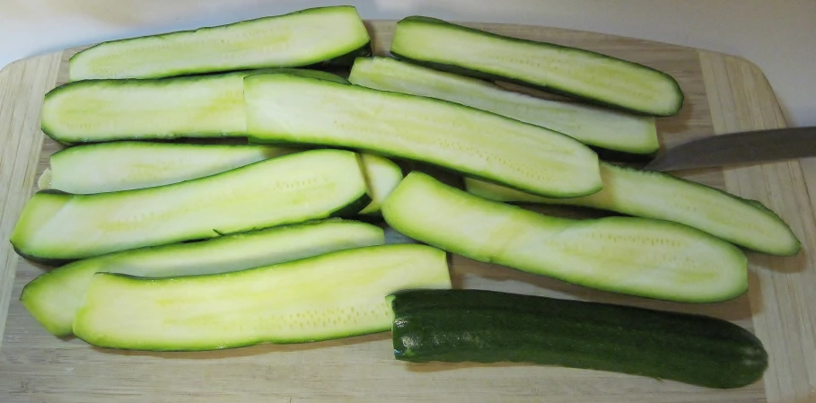 some sliced up vegetables on a board with a knife