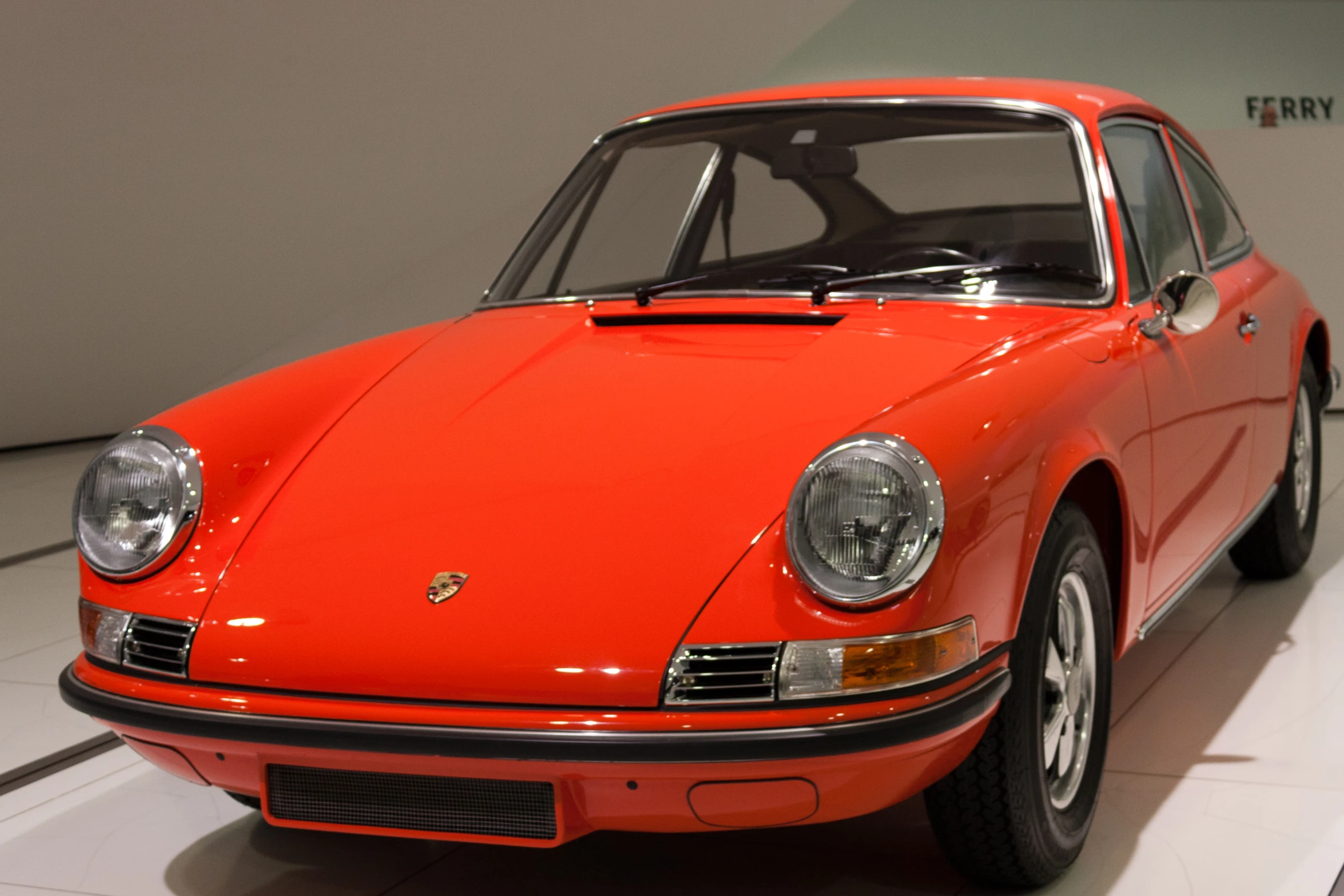 this bright orange porsche is on display in the museum