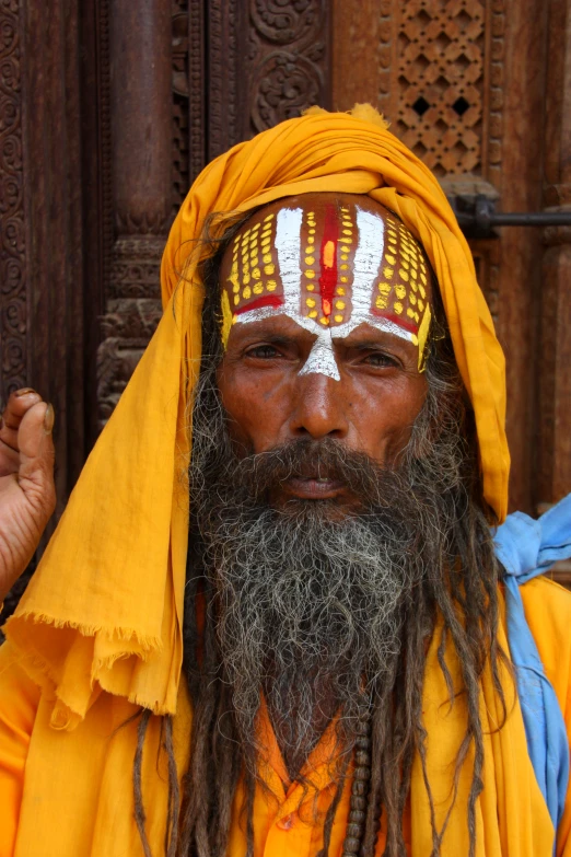 an indian man with long hair, white eyes and grey beard