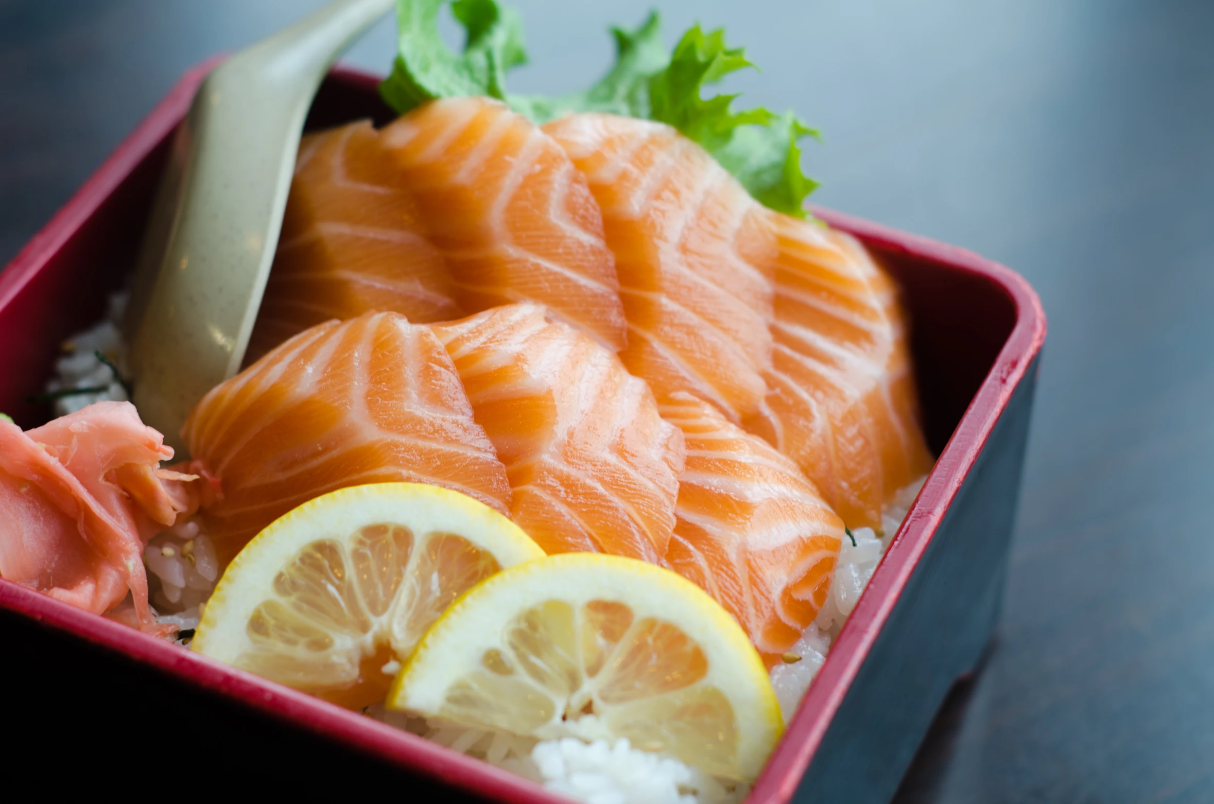 some kind of box of fish, rice, and lemon slices