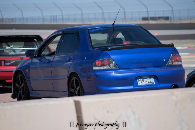 a blue compact car driving through traffic