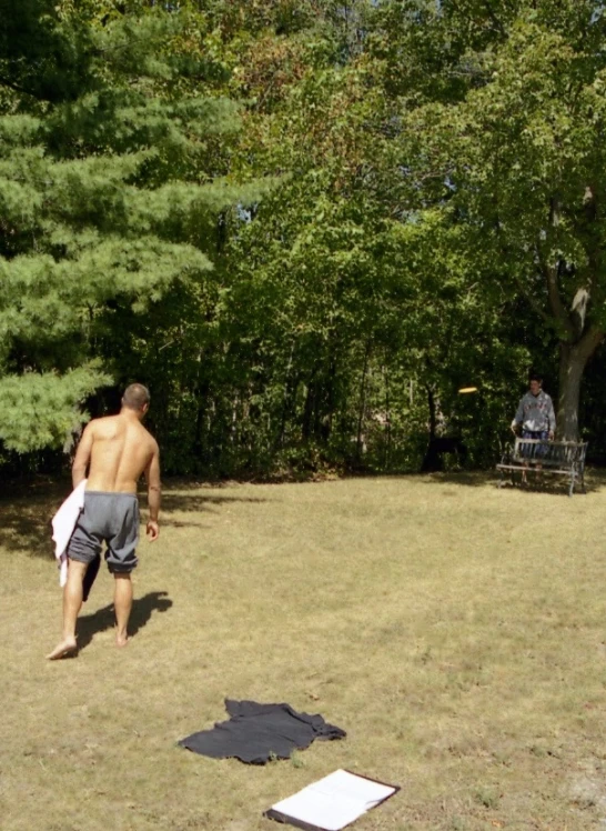 there is a man without a shirt on playing frisbee