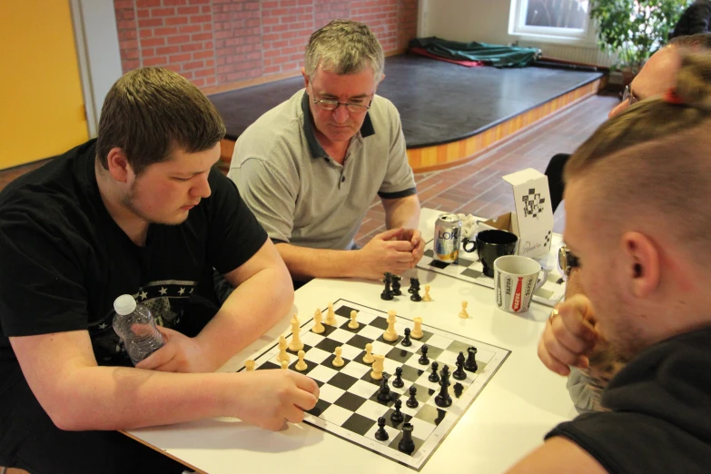 group of people sitting around table with chess