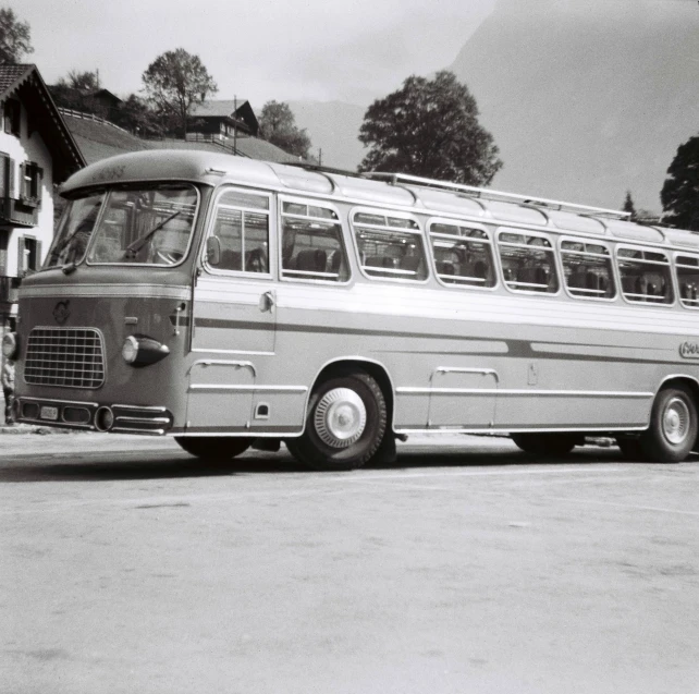 old grey and white bus parked in a lot