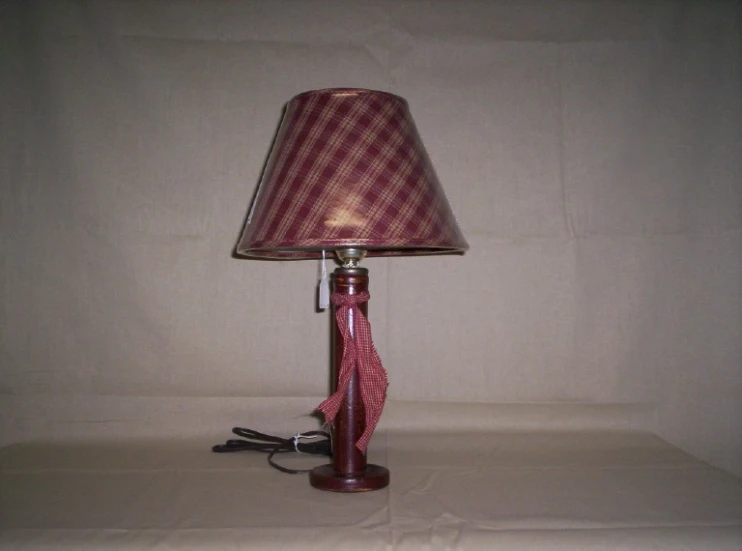 a small red and white lamp on top of a wooden table