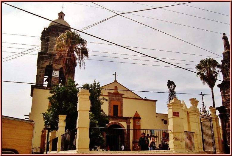 there is an old building with a tall tower behind a gate