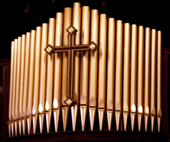 the back of a pipe organ with a cross at the top