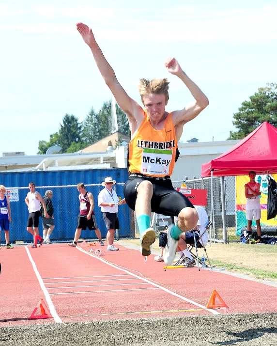 a man jumping in the air while wearing an orange shirt