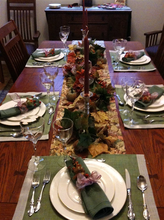 a very large dinner table with leaves and place settings